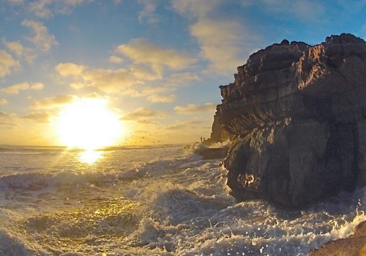 Waves break against the rocks at the northern end of Dog Beach in Del Mar.