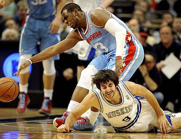 Clippers point guard Chris Paul tries to gather a loose ball in a battle with Timberwolves guard Ricky Rubio during the second half Monday night in Minneapolis.
