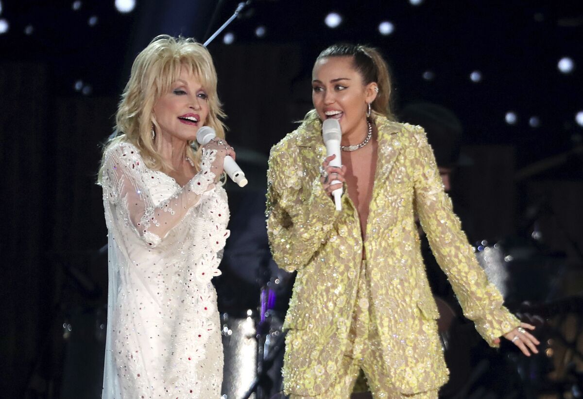 FILE - Dolly Parton, left, and Miley Cyrus perform "Jolene" at the 61st annual Grammy Awards in Los Angeles on Feb. 10, 2019. Administrators at Heyer Elementary School in Waukesha, Wis., aren't letting a first-grade class perform "Rainbowland," a Cyrus and Parton duet from Cyrus' 2017 album "Younger Now," promoting LGBTQ acceptance, because they say the song could be seen as controversial. (Photo by Matt Sayles/Invision/AP, File)