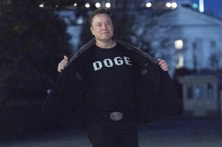 Elon Musk flashing a 'DOGE' T-shirt