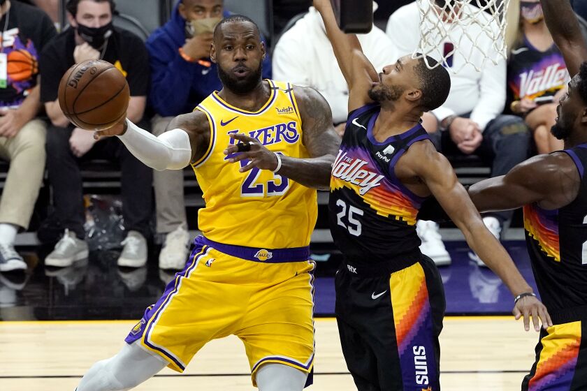 Los Angeles Lakers forward LeBron James dishes off as Phoenix Suns forward Mikal Bridges defends during a game, June 1, 2021.