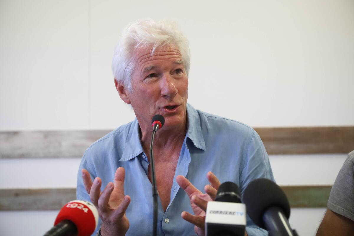 Richard Gere gestures as he speaks during a news conference in 2019.