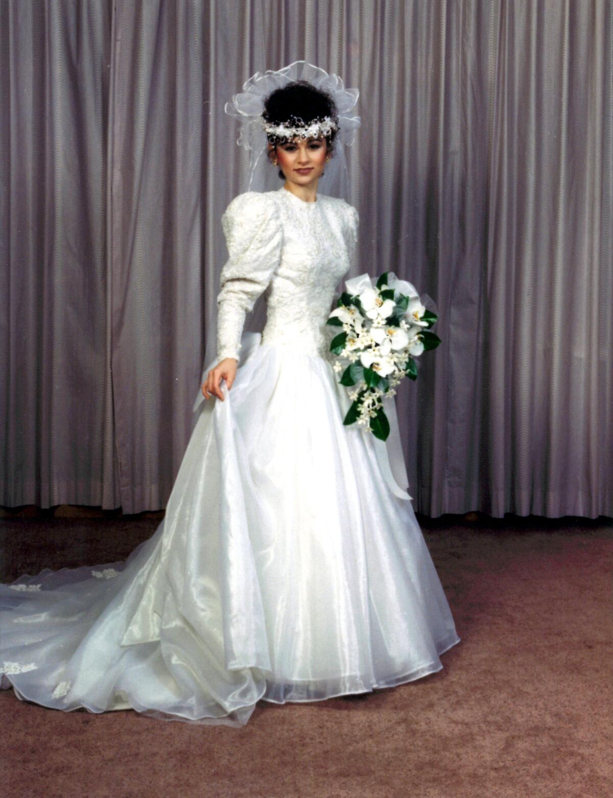 A woman in a long-sleeved white wedding gown.