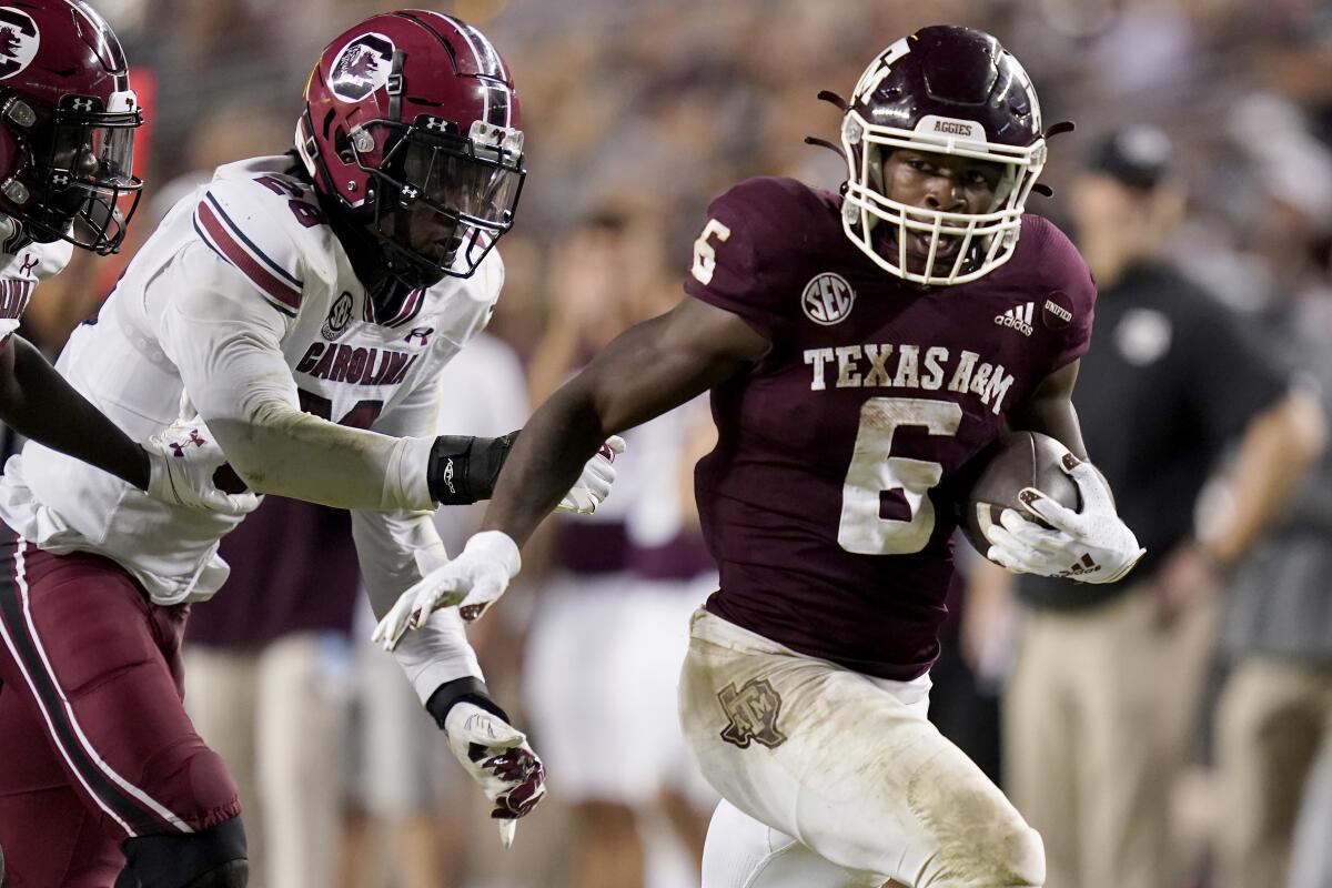 FILE - Texas A&M running back Devon Achane (6) outruns South Carolina defensive back Marcellas Dial (24) for a 35-yard touchdown run during the second half of an NCAA college football game Oct. 23, 2021, in College Station, Texas. Texas A&M is set to kick off its season on Sept. 3, 2022, against Sam Houston State. (AP Photo/Sam Craft, File)