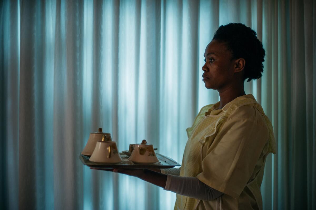 A woman carries a tray with tea service on it in the movie "Good Madam."