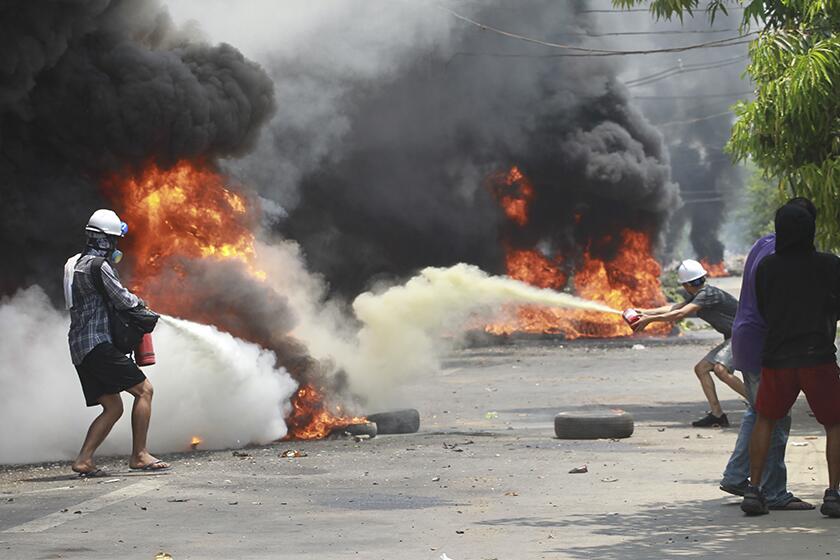 Anti-coup protesters extinguish fires during a protest in Yangon, Myanmar, on Saturday.