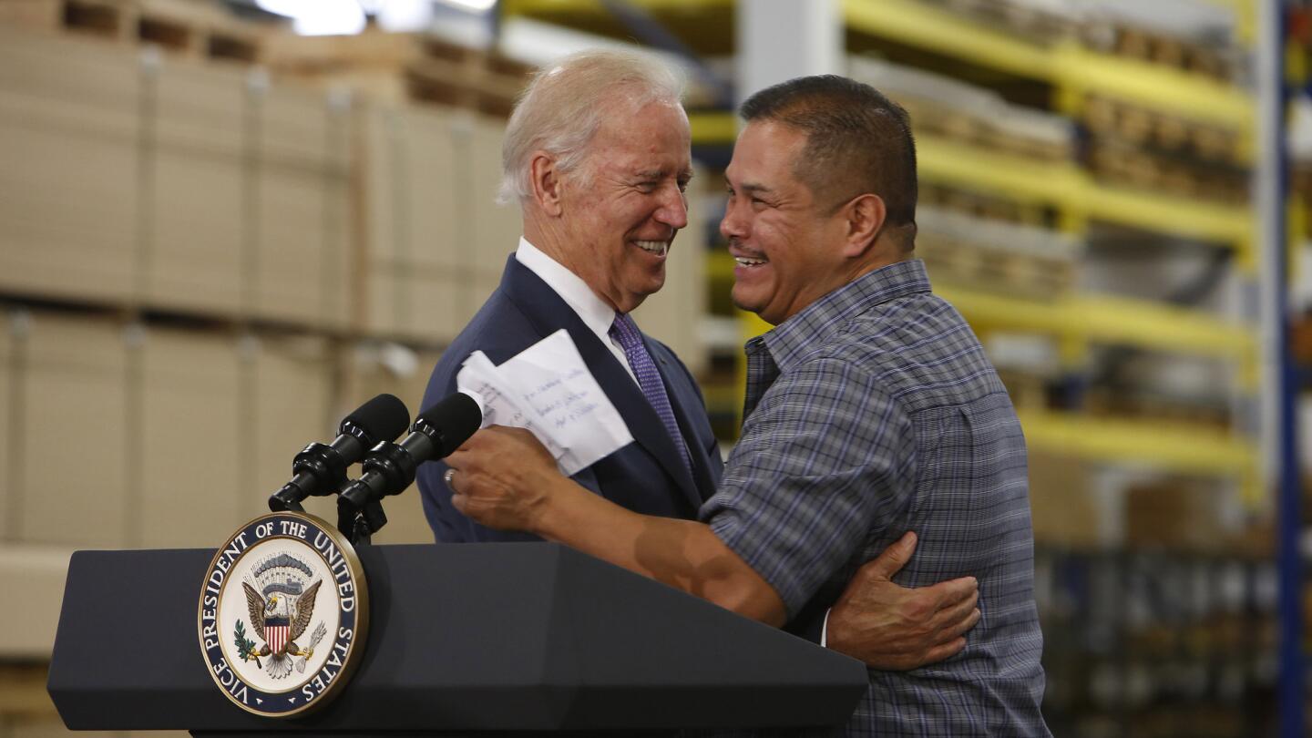 Vice President Joe Biden embraces Bobrick Washroom Equipment employee Rigoberto Hernandez, who has worked for the company for 29 years. Biden spoke July 22 at the company in North Hollywood to push for an increase in the minimum wage and expansion of overtime protections.