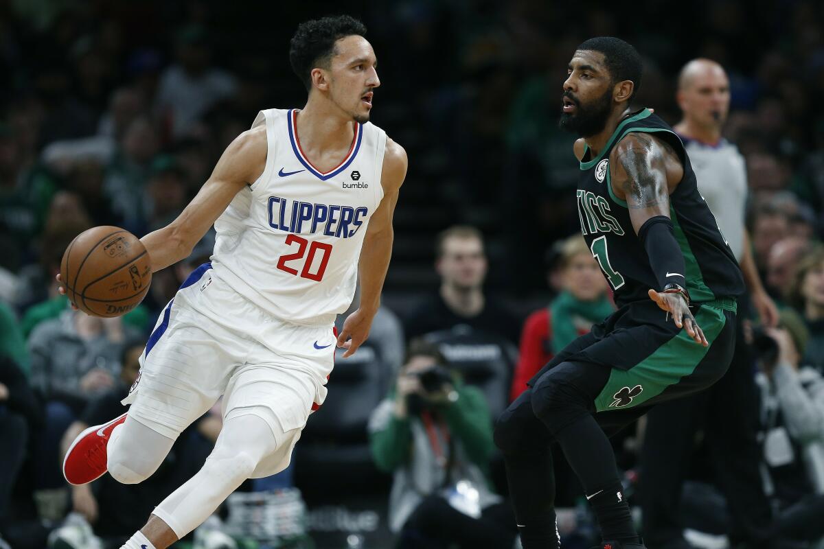 Landry Shamet drives past Boston Celtics guard Kyrie Irving during his debut for the Clippers at TD Garden on Feb. 9, 2019.