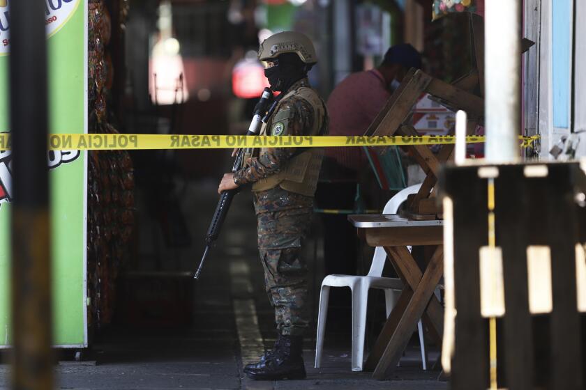 Un soldado vigla el perímetro de un sitio donde se cometió un delito en un pequeño mercado, el domingo 27 de marzo de 2022, en San Salvador, El Salvador. (AP Foto/Salvador Meléndez)
