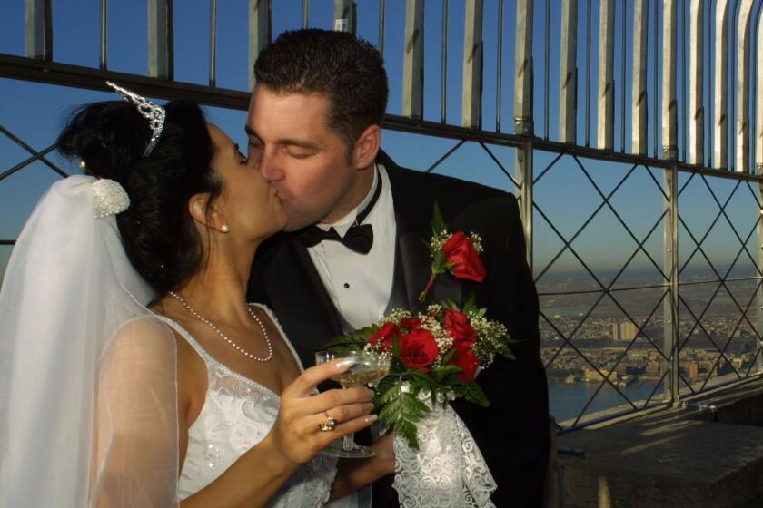 Newlyweds Caroline and Rob Driscoll, from Danbury Conn., kiss after they tied the knot in Valentine's Day marriage ceremonies Thursday Feb. 14, 2002, atop New York's Empire State Building. Twelve couples out of twenty, were chosen to tie the knot on Valentine's Day marriage ceremonies and were married earlier on the 80th floor Sky Lobby of the Empire State Building.(AP Photo/John-Marshall Mantel)