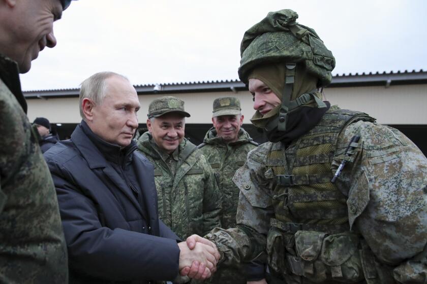 FILE - Russian President Vladimir Putin shakes hands with a soldier as he visits a military training centre of the Western Military District for mobilised reservists as Russian Defense Minister Sergei Shoigu, center, smiles in Ryazan Region, Russia, Thursday, Oct. 20, 2022. The mobilized reservists that Russian President Vladimir Putin visited last week at a firing range southeast of Moscow looked picture-perfect. (Mikhail Klimentyev, Sputnik, Kremlin Pool Photo via AP, File)