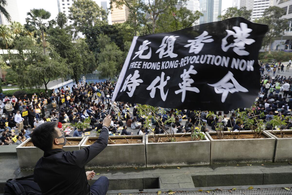 A pro-democracy supporter waves a flag during a rally by the advertising industry in Hong Kong on Monday. Thousands of people took to Hong Kong's streets Sunday in a new wave of protests, but police fired tear gas after some demonstrators hurled bricks and smoke bombs, breaking a rare pause in violence that has persisted during the six-month-long movement.