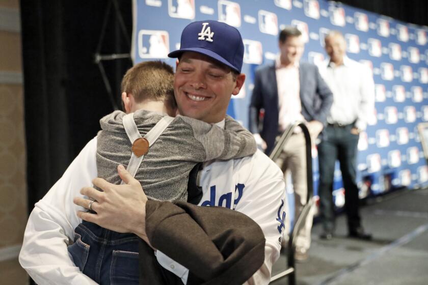 Rich Hill hugs his son Brice, 5, after the pitcher's new three-year deal with the Dodgers was announced at Major League Baseball's winter meetings on Dec. 5.