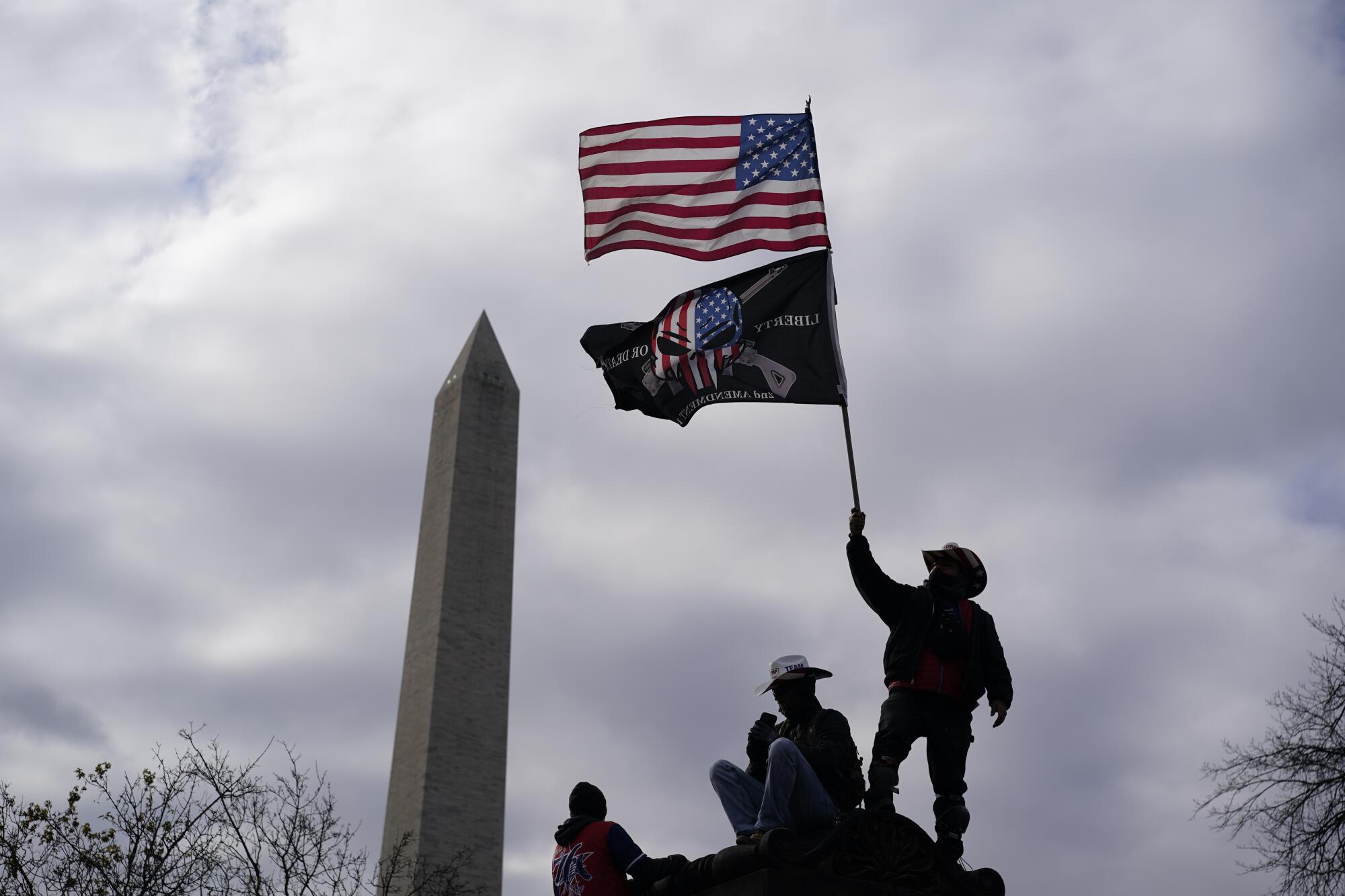 Trump supporters wave flags in front of the Washington Monument.