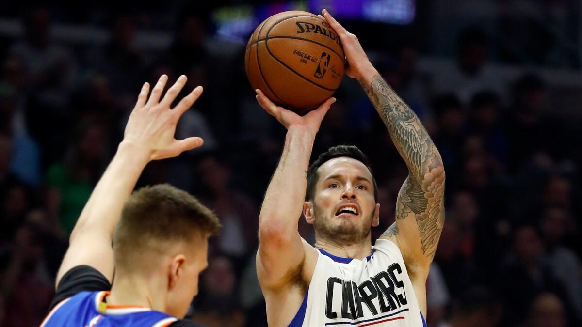 The Clippers' J.J. Redick shoots over New York's Kristaps Porzingis on Monday at Staples Center.