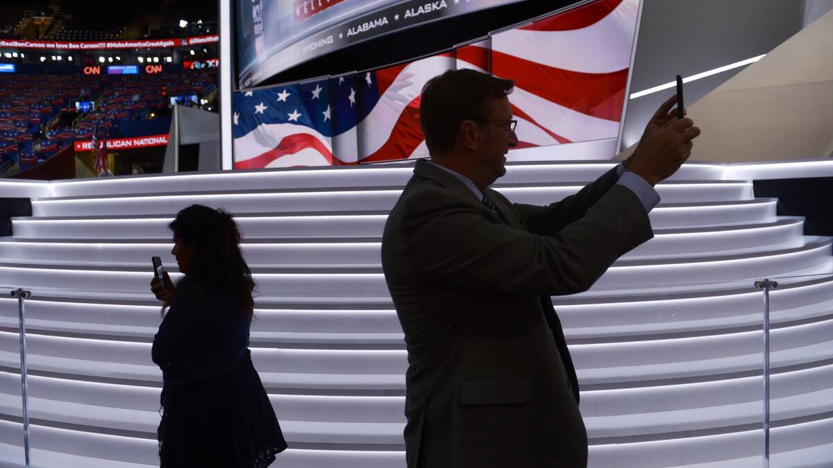 People use their mobile phones as preparations are underway at Quicken Loans Arena for day three of the Republican National Convention in Cleveland, Ohio on July 20, 2016.