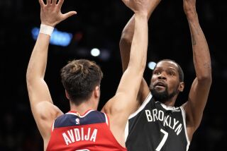 El alero de los Nets de Brooklyn Kevin Durant lanza el balón el alero de los Wizards de Washington Deni Avdija en el encuentro del miércoles 30 de noviembre del 2022. (AP Foto/John Minchillo)