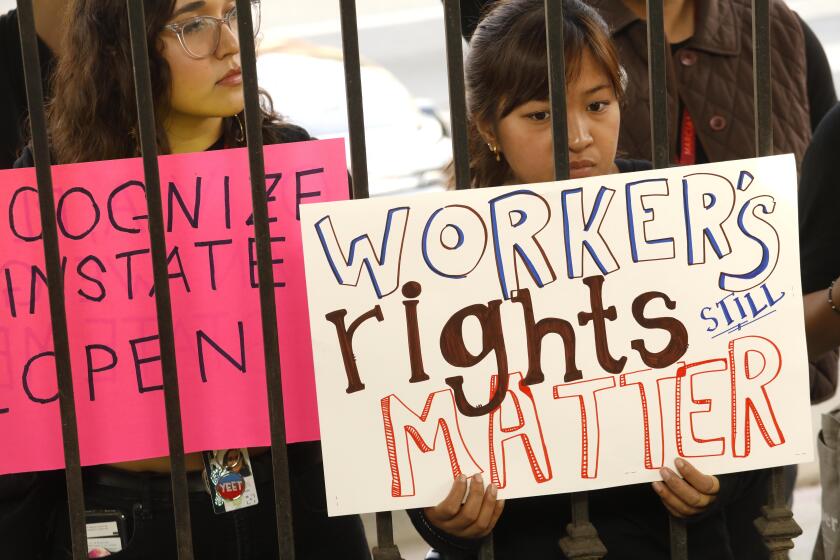 WEST HOLLYWOOD, CA - NOVEMBER 15, 2019 - - Nina Gibson, from left, and Anna Calubayan join fellow Marciano Art Foundation workers, recently laid off, in a protest in front of LAXART along Santa Monica Blvd. in West Hollywood on November 15, 2019. Labor organizers in Los Angeles have accused the Marciano Art Foundation, a private museum, of violating federal law by dismissing 70 employees after they announced that they wanted to form a union. Workers chose this site to protest because Olivia Marciano, the Foundation’s Artistic Director, is on the board at LAXART. Gibson and Calubayan were both visitor services associates at the MAF. (Genaro Molina / Los Angeles Times)