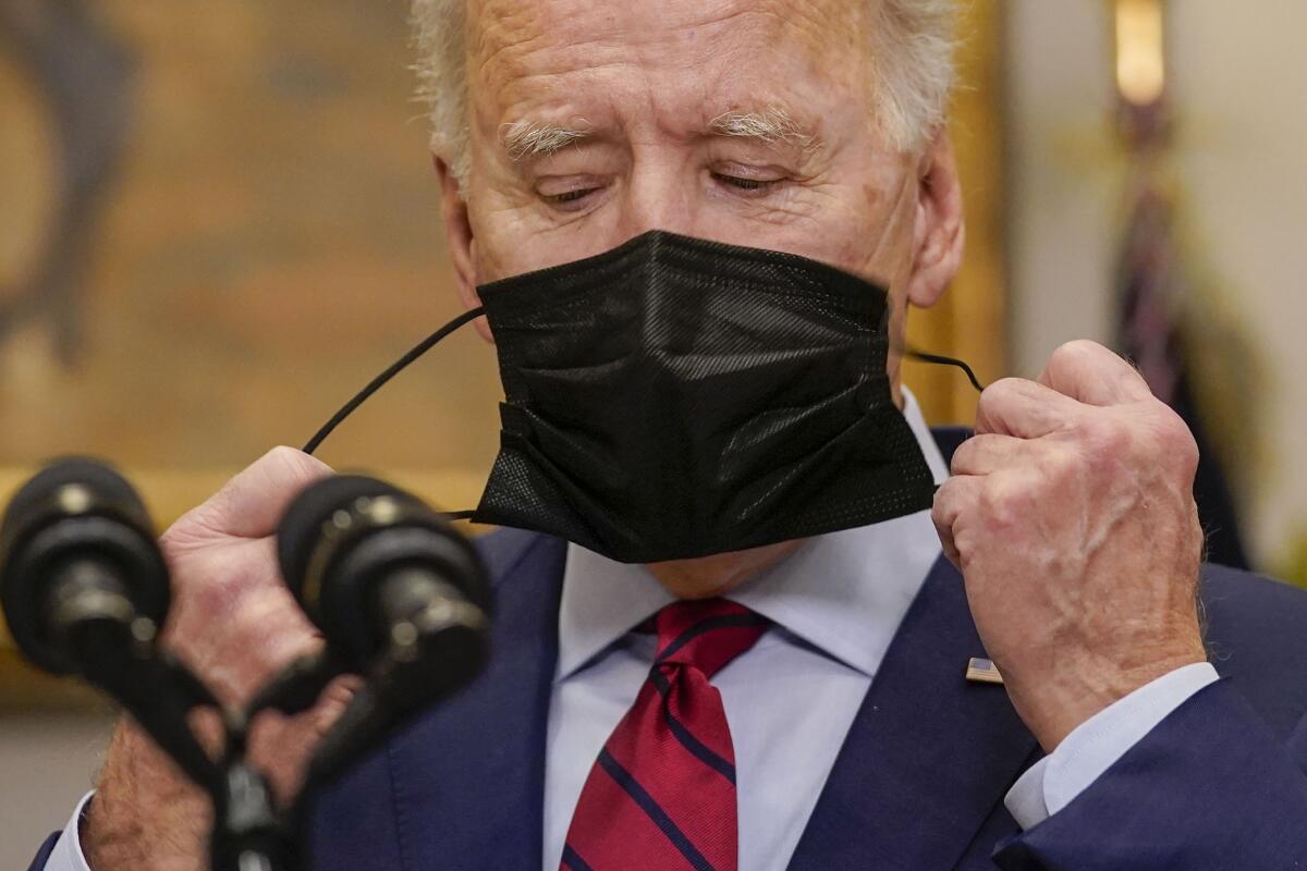 President Joe Biden removes his mask