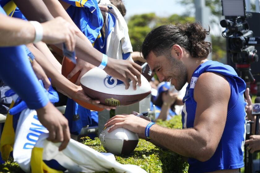 Los Angeles Rams wide receiver Puka Nacua (17) signs autographs for fans at the end of the NFL football team's training camp Saturday, July 27, 2024, at Loyola Marymount University in Los Angeles. (AP Photo/Damian Dovarganes)