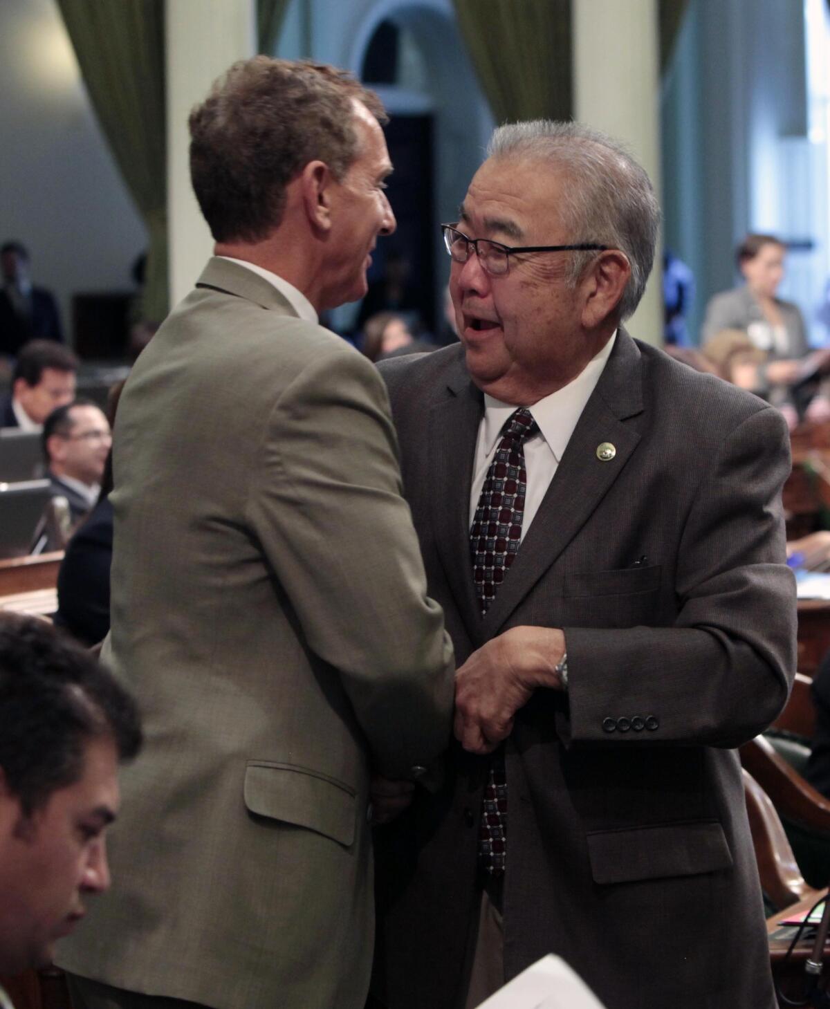 Then-Assemblyman Warren Furutani in 2012, being congratulated by then-Assemblyman Bob Wieckowski after his pension reform bill was approved by the Assembly.