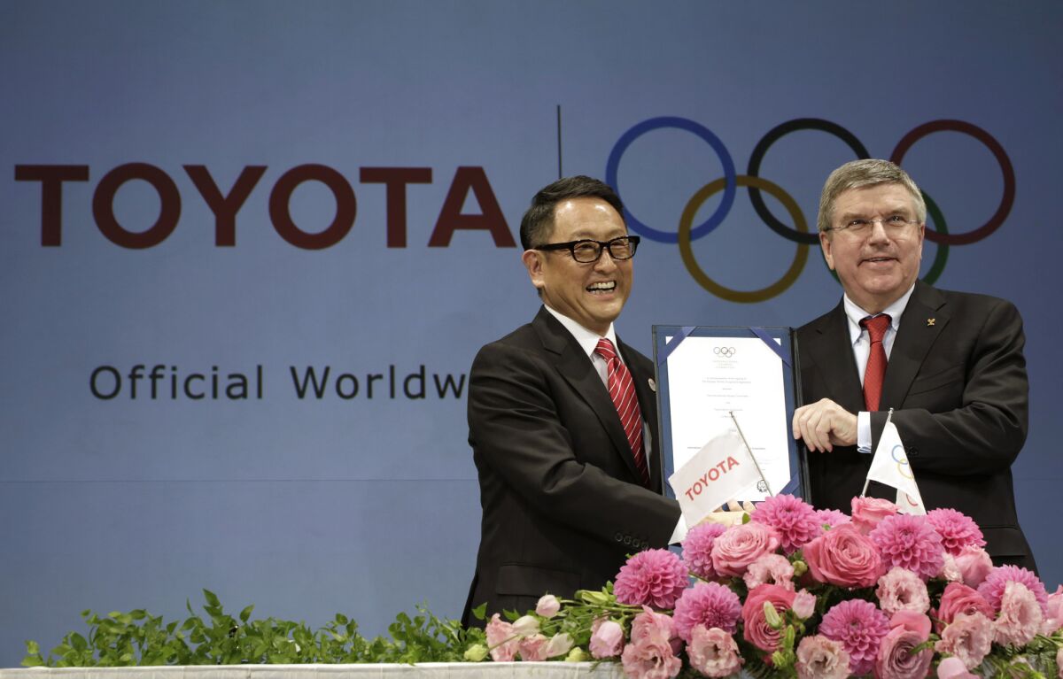 Toyota President and CEO Akio Toyoda, left, and International Olympic Committee President Thomas Bach announced the new sponsorship deal at a news conference Friday in Tokyo.