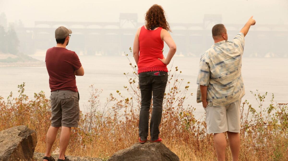 People check out the smoky view of the Eagle Creek fire from North Bonneville Dam in the Columbia River Gorge.