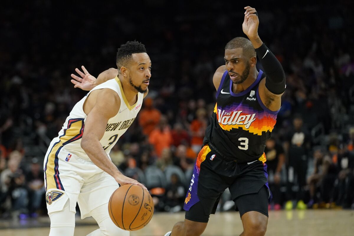 New Orleans Pelicans guard CJ McCollum drives as Phoenix Suns guard Chris Paul defends.