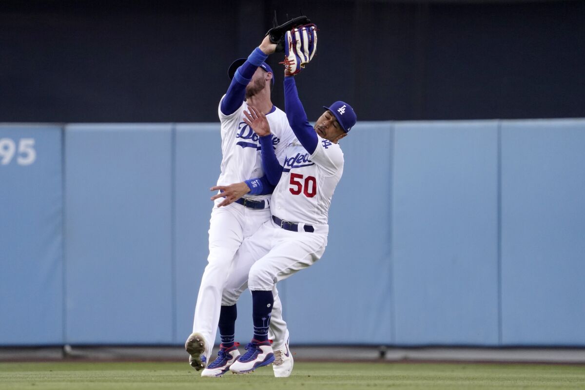 Los Angeles Dodgers right fielder Mookie Betts, right, collides with center fielder Cody Bellinger after making a catch on a ball hit by Los Angeles Angels' Taylor Ward during the first inning of a baseball game Wednesday, June 15, 2022, in Los Angeles. Betts lost control of the ball after the collision but Ward was thrown out at second by Bellinger. (AP Photo/Mark J. Terrill)