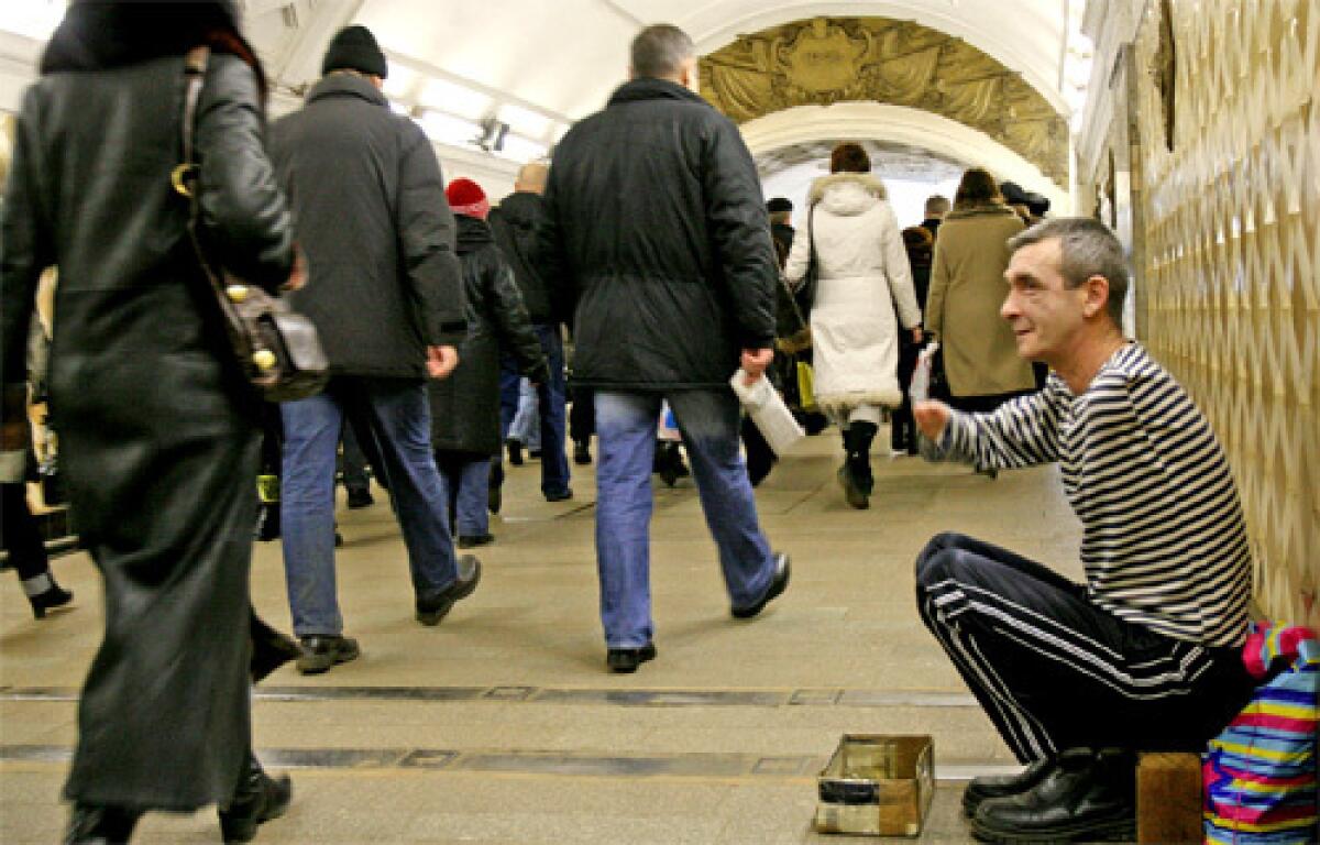 A disabled man begs in the Moscow Metro. When you take that escalator down and look at those faces, get hit with all of that anxiety, all of the worry, its incredible, one Russian says of the subway.