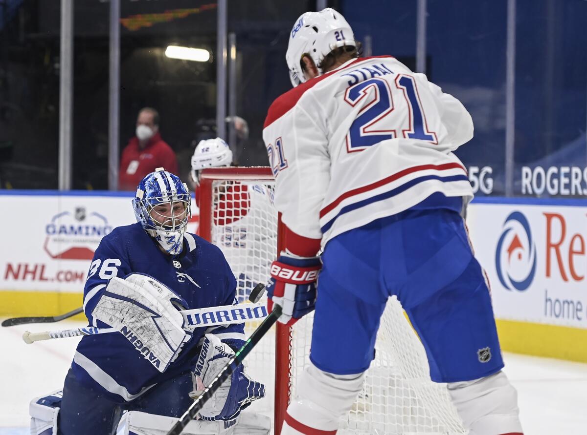 Toronto Maple Leafs goaltender Jack Campbell (36) bats the puck out of the air as Montreal Canadiens forward Eric Staal (21) keeps close during the second period of an NHL hockey game Wednesday, April 7, 2021, in Toronto. (Nathan Denette/The Canadian Press via AP)