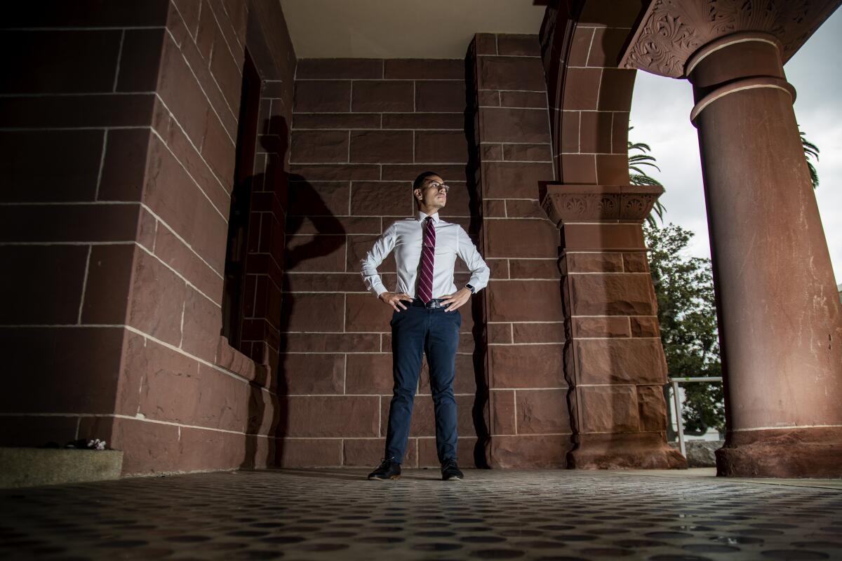 A man in a suit stands for a portrait 