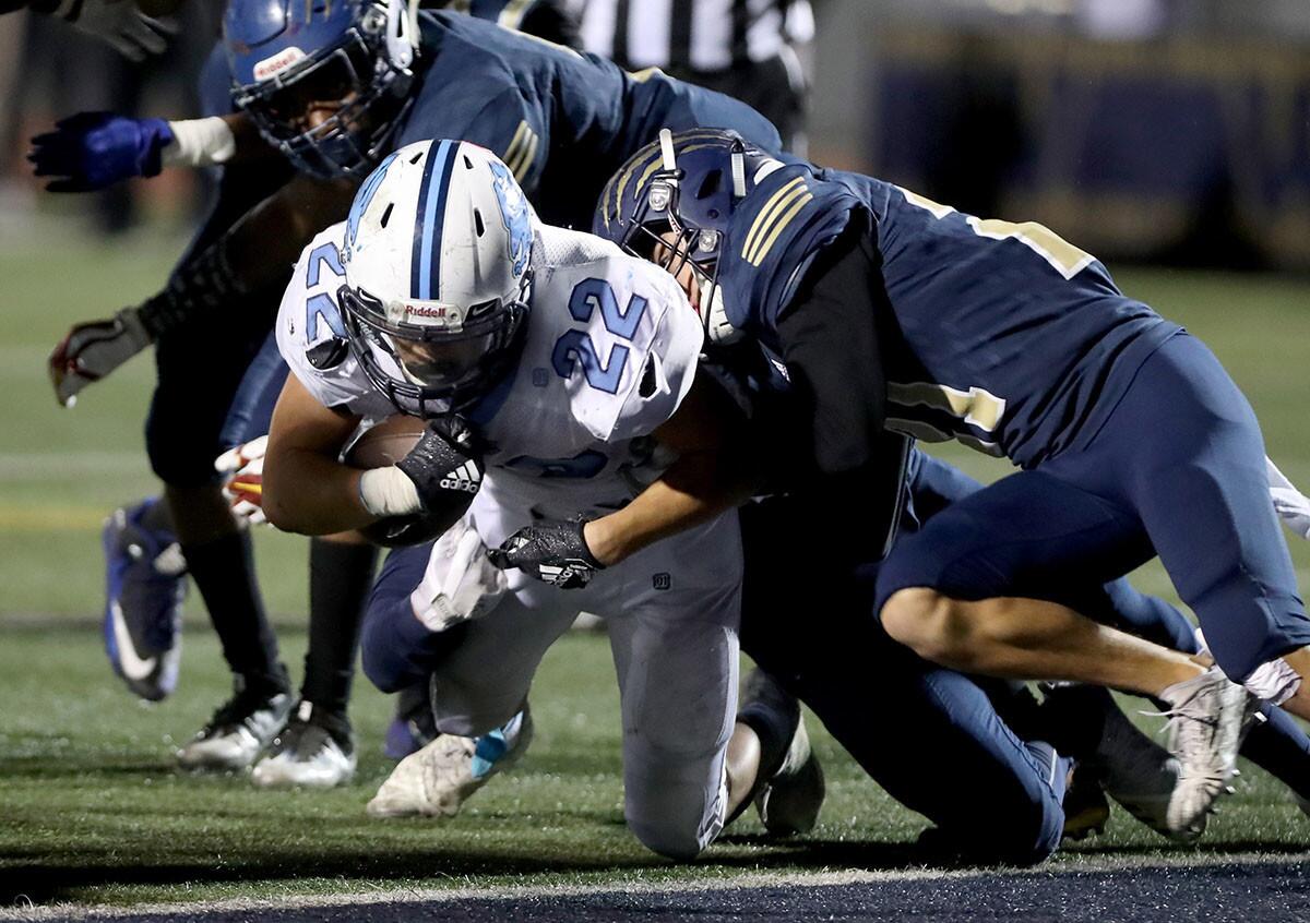 Crescenta Valley High School football player #22 Daniel Cho drags the defense five yards and scores a touchdown in the second quarter in CIF SS Div. 7 first round game at Warren High School in Downey on Friday, Nov. 2, 2018.