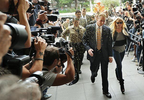 Lindsay Lohan walks through confetti as she arrives at the courthouse. After Lohan's court appearance, a couple of unmarked cars pulled up to the side of the courthouse to take her to jail. Paparazzi crowded around the vehicles to snap pictures through the tinted windows