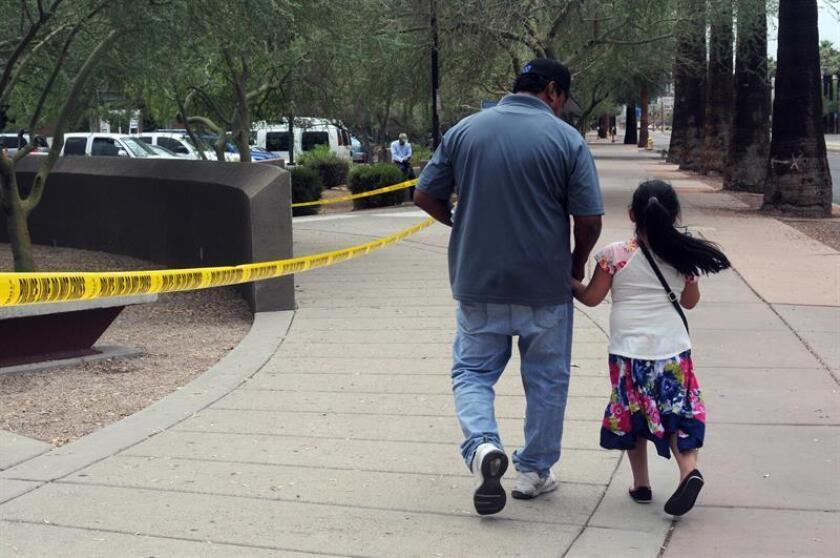 Un hombre camina junto a su hija tras salir de una cita en la Oficina de Control de Inmigración y Aduanas (ICE), desde donde supuestamente se transportará a los menores de 5 años liberados para reunificarlos con sus padres. EFE/Archivo