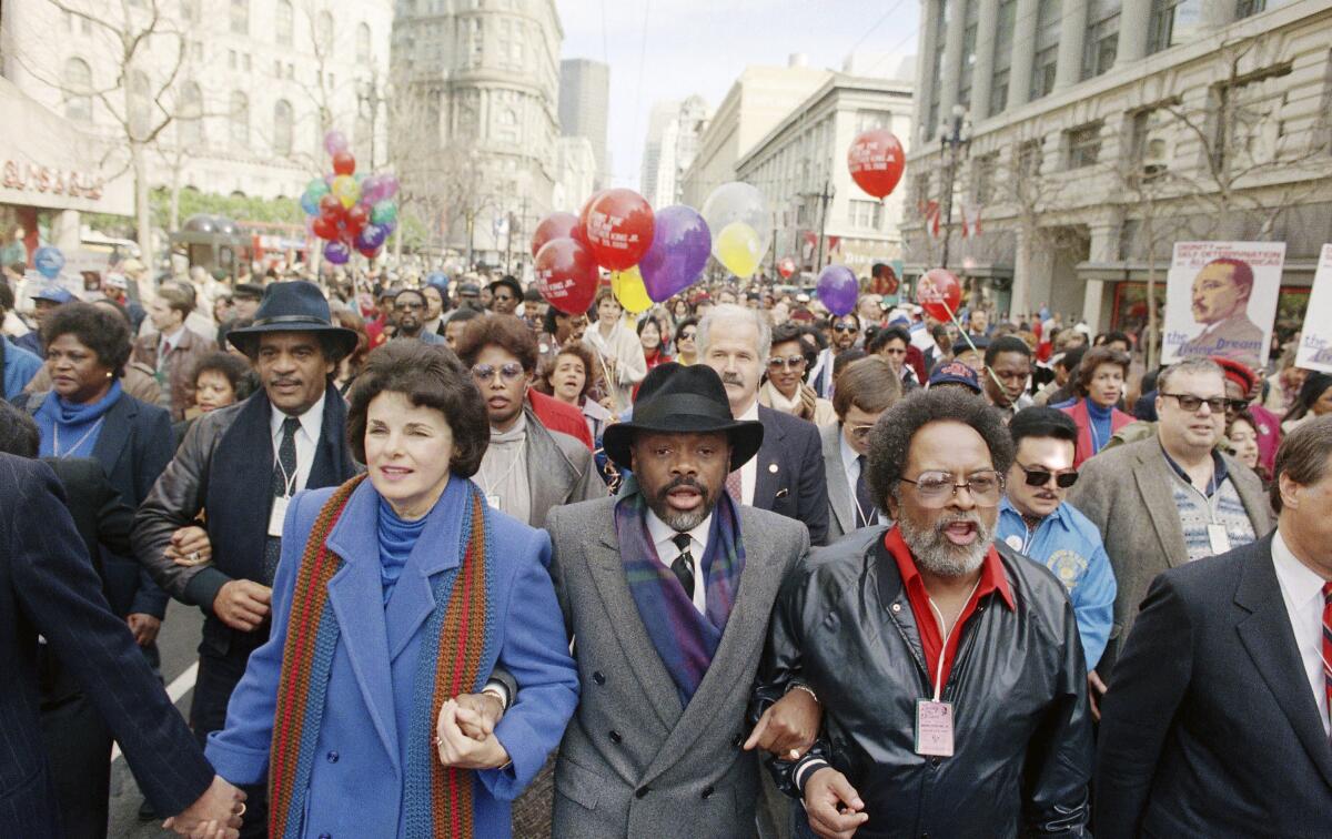 Dianne Feinstein, Willie Brown and Cecil Williams hold hands during a march.