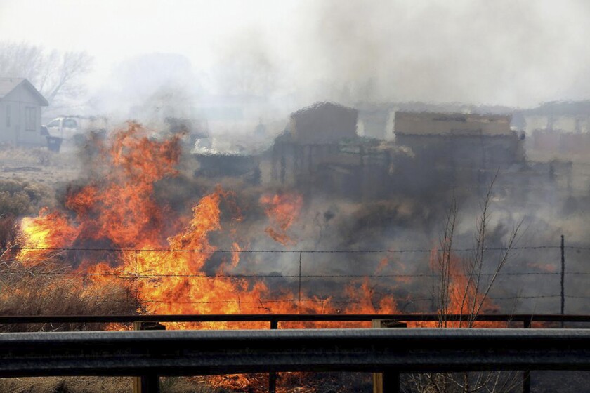 A wind-driven wildfire burns at the edge of U.S. 89 on the outskirts of Flagstaff, Ariz., on Tuesday, April 19, 2022. An Arizona wildfire doubled in size overnight into Wednesday, a day after heavy winds kicked up a towering wall of flames outside a northern Arizona tourist and college town, ripping through two dozen structures and sending residents of more than 700 homes scrambling to flee. (Jake Bacon/Arizona Daily Sun via AP)