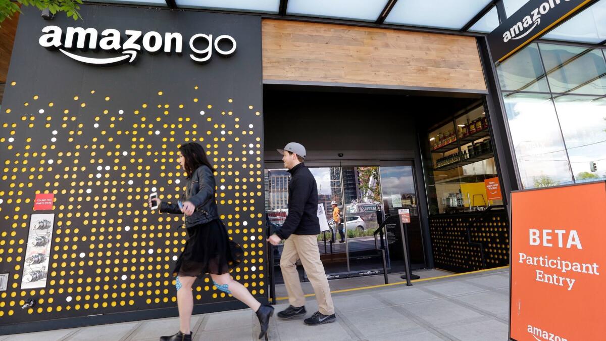 People walk past the Amazon Go store in Seattle.