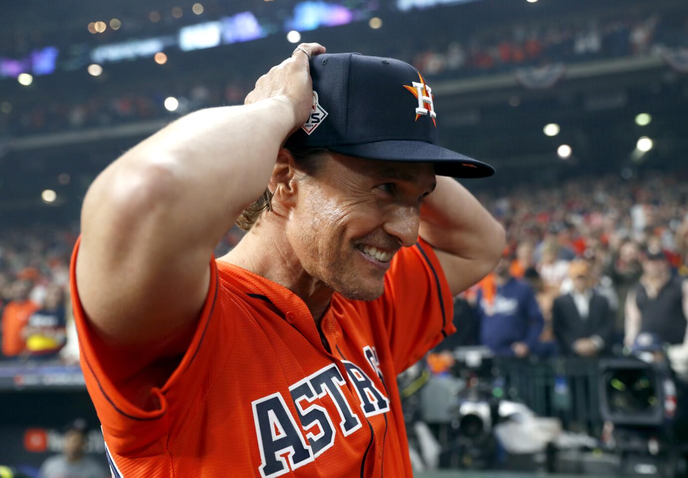 Matthew McConaughey on the field before Game 7, wearing an Astros cap and jersey.