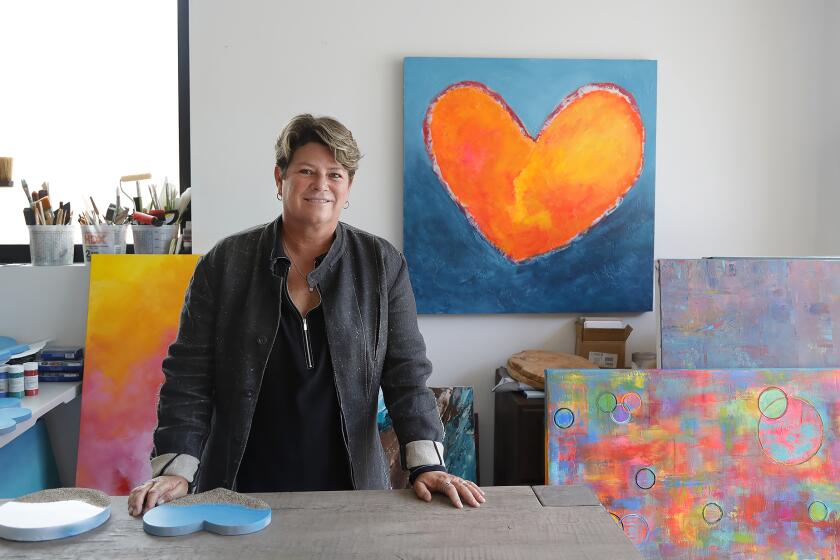 Artist Christie Smith stands in her garage studio in Laguna Beach. Smith moved from Half Moon Bay in Northern California to open an art gallery in downtown Laguna Beach. Smith mostly works in wood and resins she mixes into her own colors.