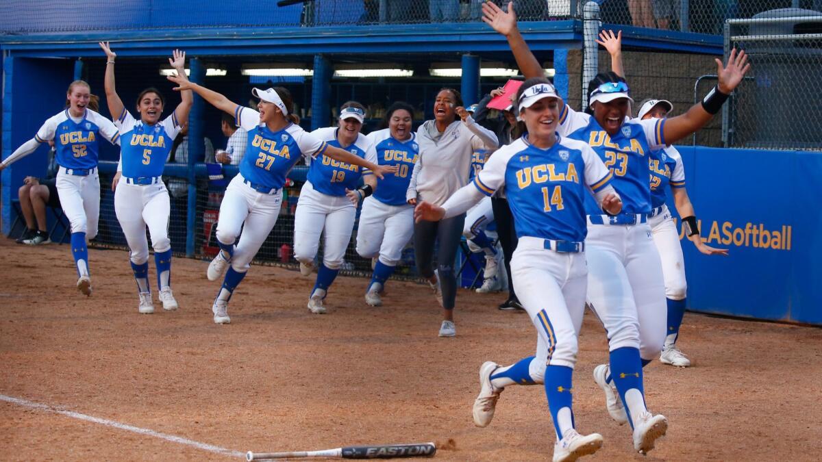 UCLA players rush to the plate to celebrate a home run by Taylor Pack during an NCAA super regional game against James Madison on Saturday at Easton Stadium.