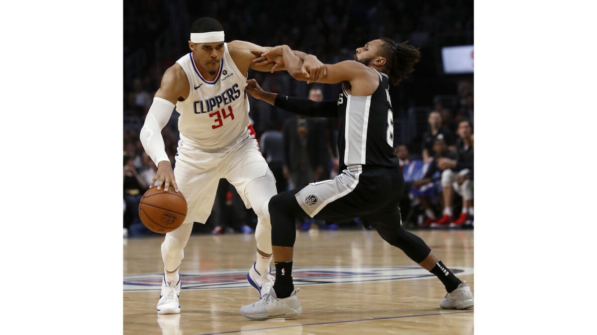 Clippers forward Tobias Harris fights his way to the basket against Spurs guard Patty Mills in the second quarter.