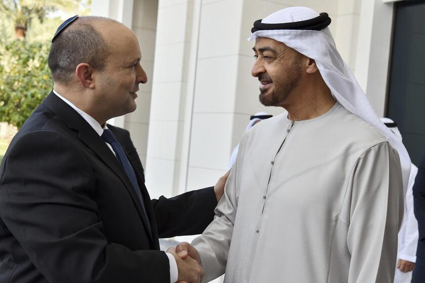 In this photo provided by the Israel Government Press Office (GPO), Israeli Prime Minister Naftali Bennett, left, is received by Abu Dhabi Crown Prince Sheikh Mohammed bin Zayed at his private palace in Abu Dhabi, Monday, Dec. 13, 2021. (Haim Zach/Israel Government Press Office via AP)