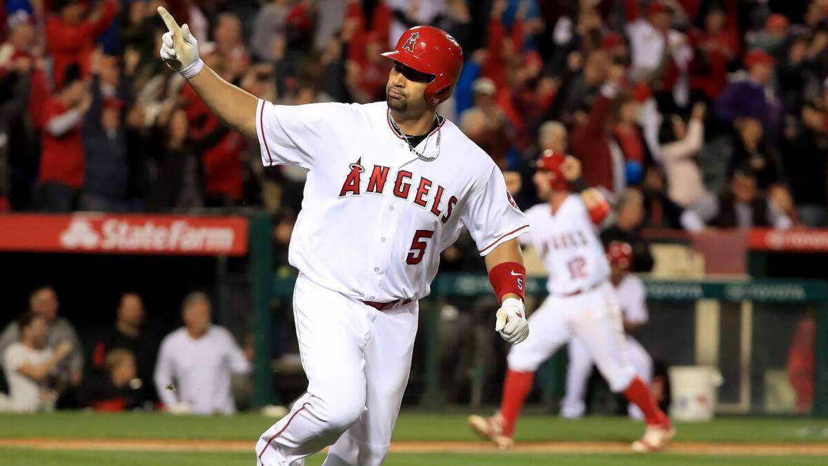 Angels designated hitter Albert Pujols celebrates after delivering the game-winning hit against the Rangers on Thursday night.