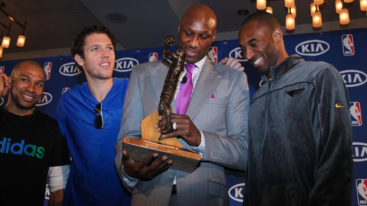 Lamar Odom receives the NBA's sixth man award while surrounded by Lakers teammates Derek Fisher, left, Luke Walton and Kobe Bryant on April 19, 2011. Odom was traded by the Lakers later that off-season.