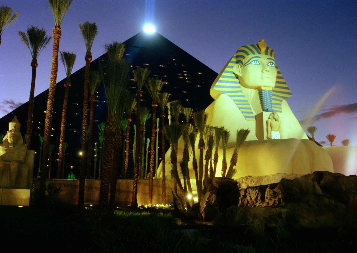 The pyramid and sphinx at the Luxor are illuminated at night.