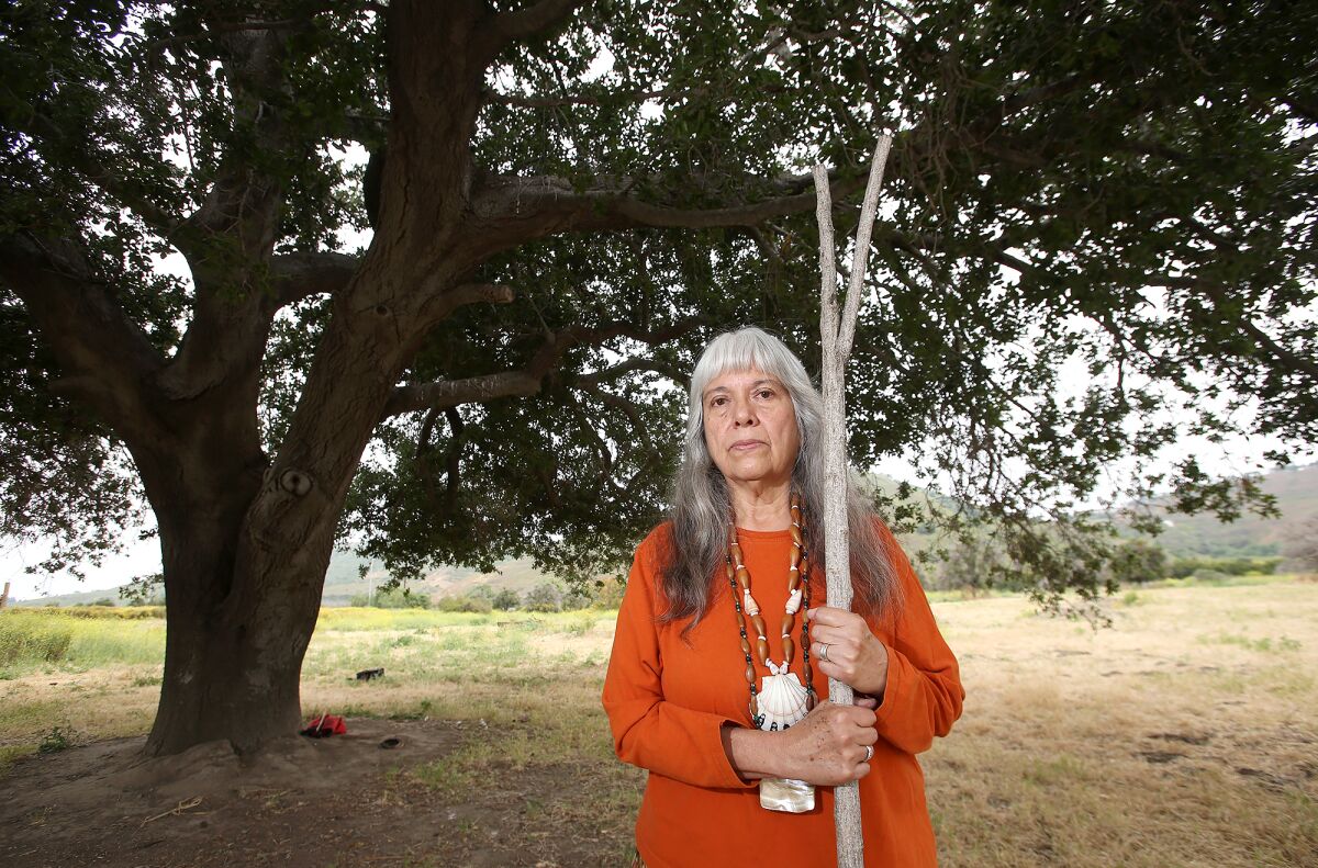 Spiritual leader Adelia Sandoval of the Juaneño Mission Indians of San Juan Capistrano stands next to an old oak tree.