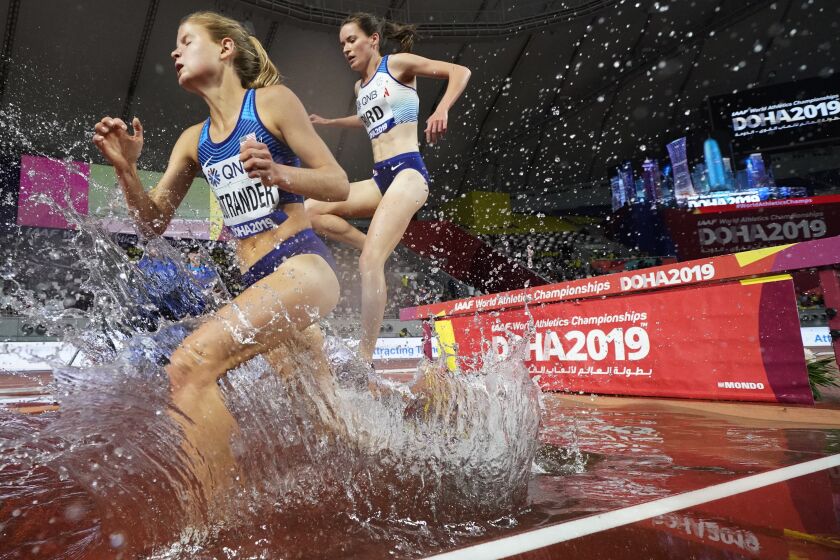 Allie Ostrander, of the United States, left, and Elizabeth Bird, of Britain, right, compete during the women 3,000 meters steeple chase heats at the World Athletics Championships in Doha, Qatar, Friday, Sept. 27, 2019. (AP Photo/David J. Phillip)