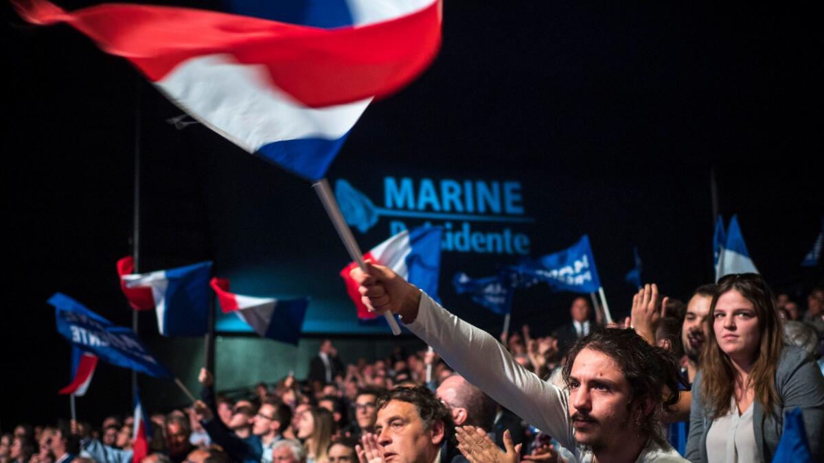Supporters cheer and wave the French flag as they listen to Marine Le Pen, French National Front political party leader, in Marseille, France, on April 19.