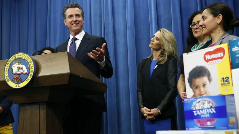 Gov. Gavin Newsom discusses a plan to suspend the state sales tax on tampons and diapers in his upcoming budget on Tuesday in Sacramento. Newsom was accompanied by First Partner Jennifer Siebel Newsom and Assemblywomen Lorena Gonzalez, third from left, and Monique Limón.